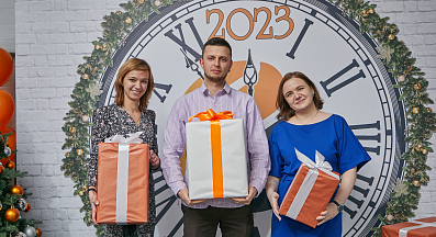 Сотрудники компании ВЕКПРОМ на фоне часов с подарками